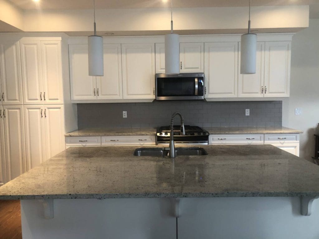 Modern white painted kitchen with stylish dark grey counter and backsplash